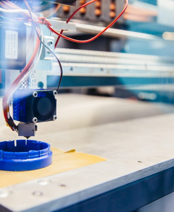 Freshly printed blue plastic detail on the platform of 3d printer